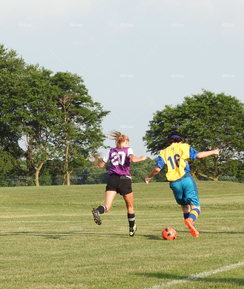 two kids fighting for the soccer ball