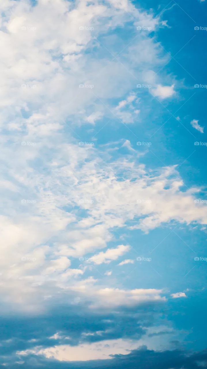 Large clouds float across the sunset sky like sails.