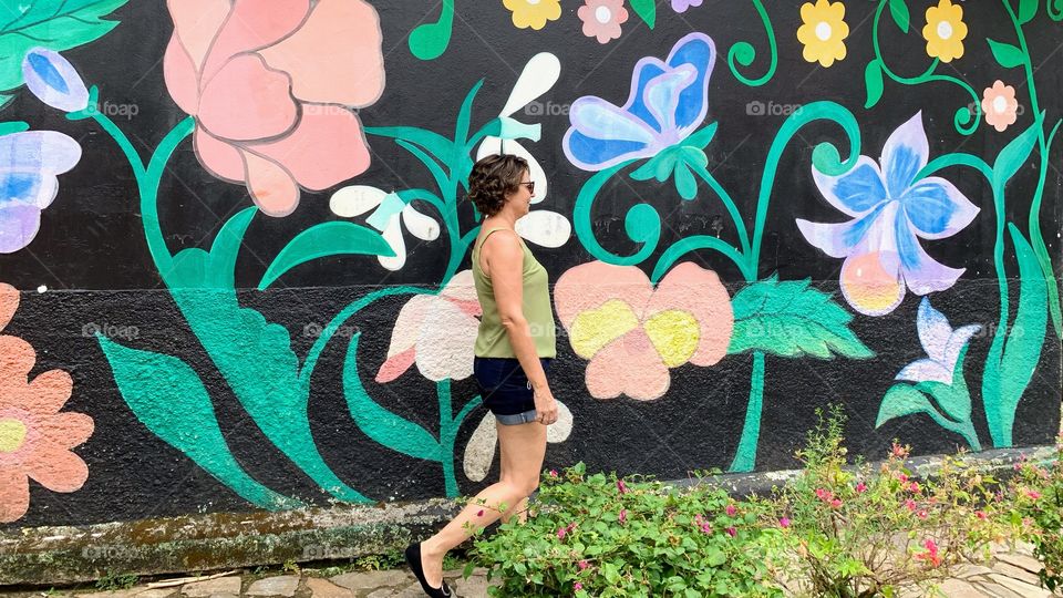 Woman walking in front of a colorful wall