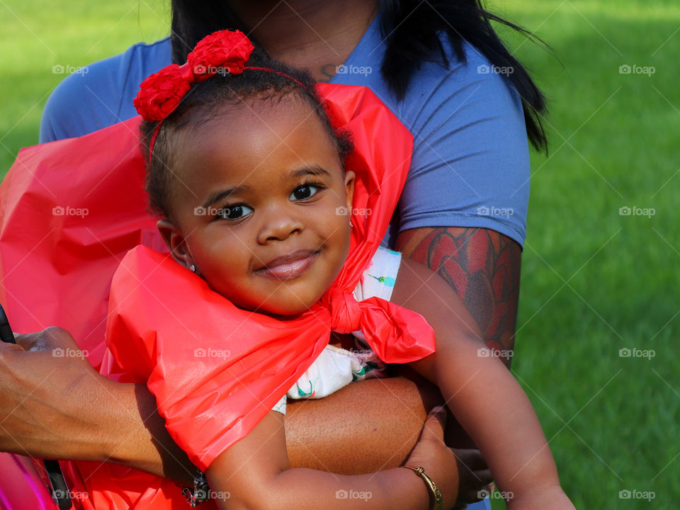 Smiling infant in red cape
