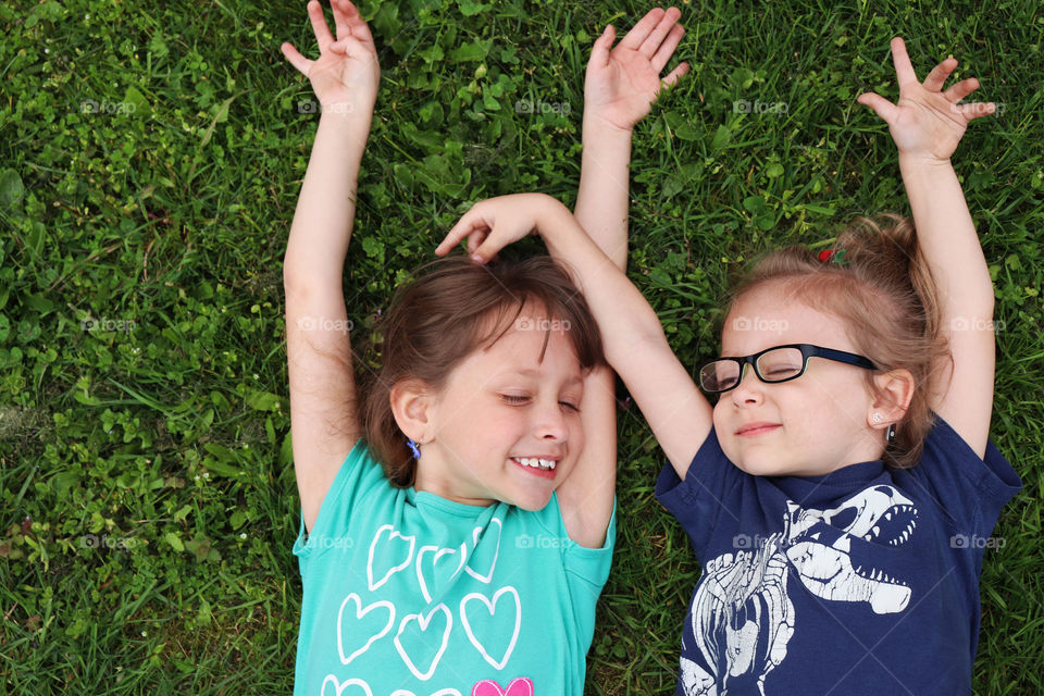 Sisters relaxing in the grass together