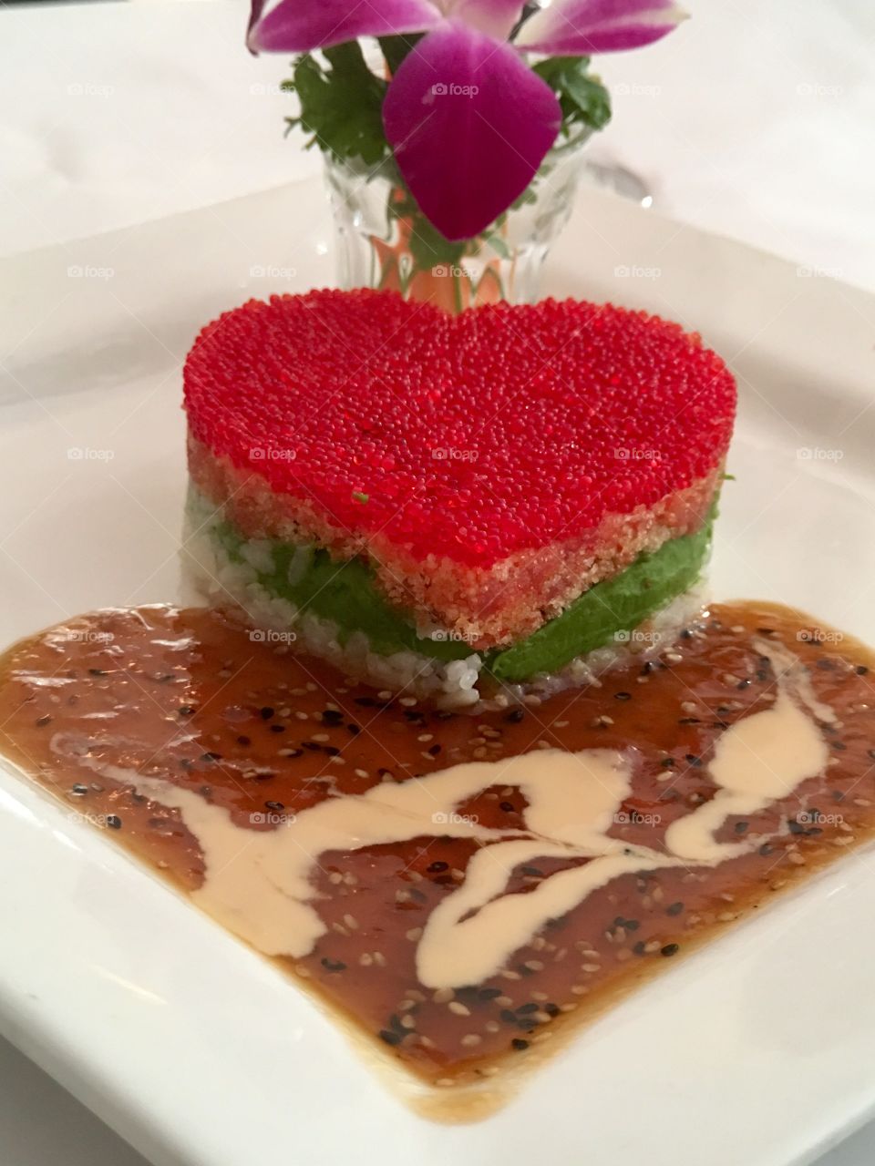 Heart shaped sushi plate featuring red salmon roe, salmon, artfully plated 