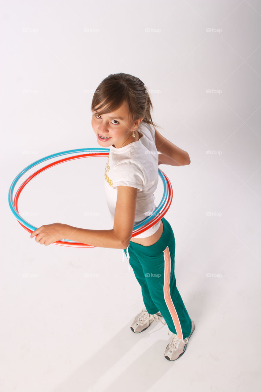 High angle view of a girl playing hula hoop on white background