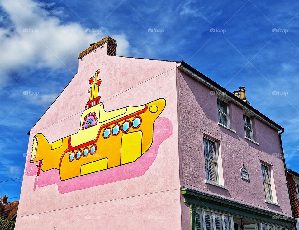 Mural of The Beatles Yellow Submarine on the wall of a pink Victorian house in Rowhedge, Essex