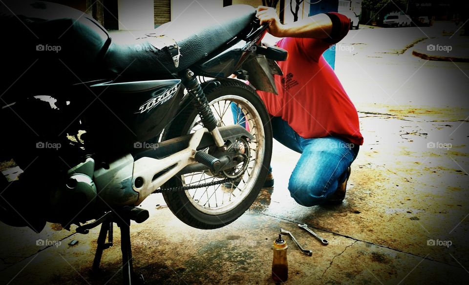 Revisões, oficina mecânica, consertos de motos. Esticando e lubrificando a corrente.