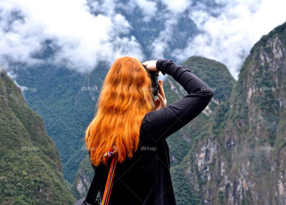 Woman with camera photographing the Andes Mountains