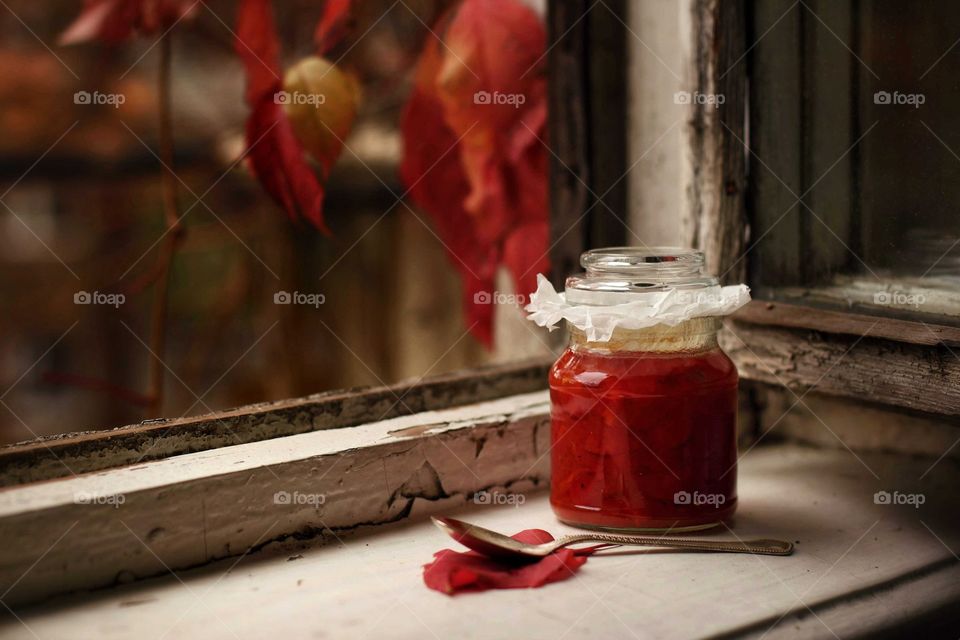 Mom's rosehip jam on the windowsill of old windows