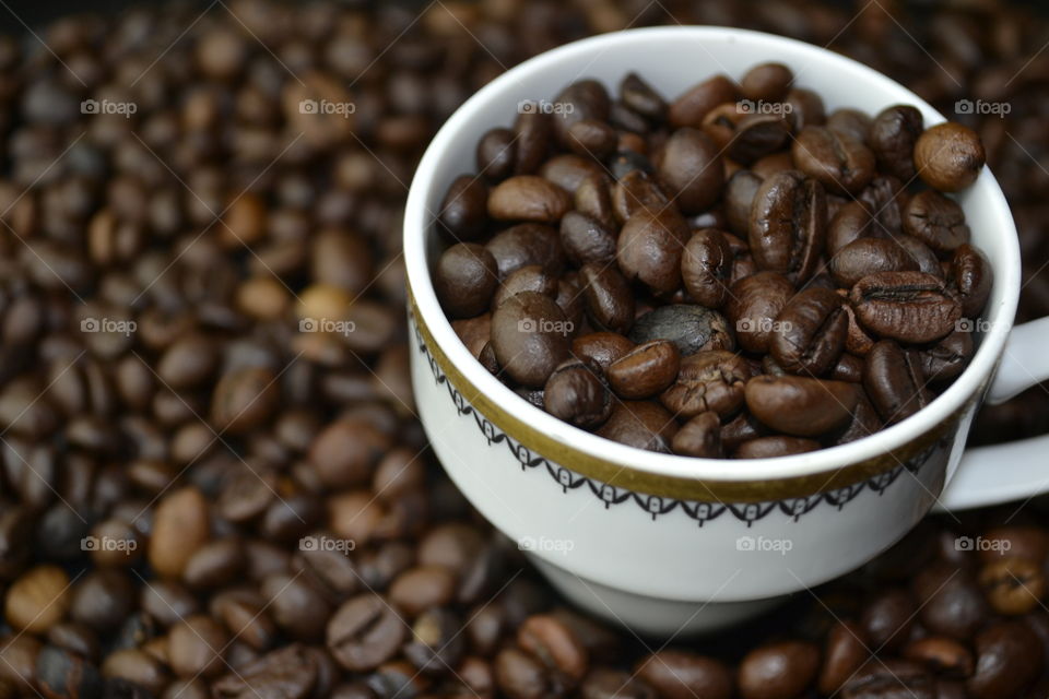 Close-up of roasted coffee beans in cup