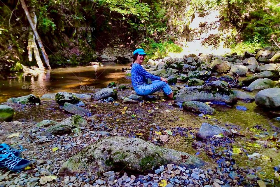 Sitting on the stones that permeate the wild water stream, the river „Ohe“ near the small township of „Ringelai“ in „Bavaria“ the water is right beside you and invites to take a dip with your feet. 2023. Hypnotic Productions
