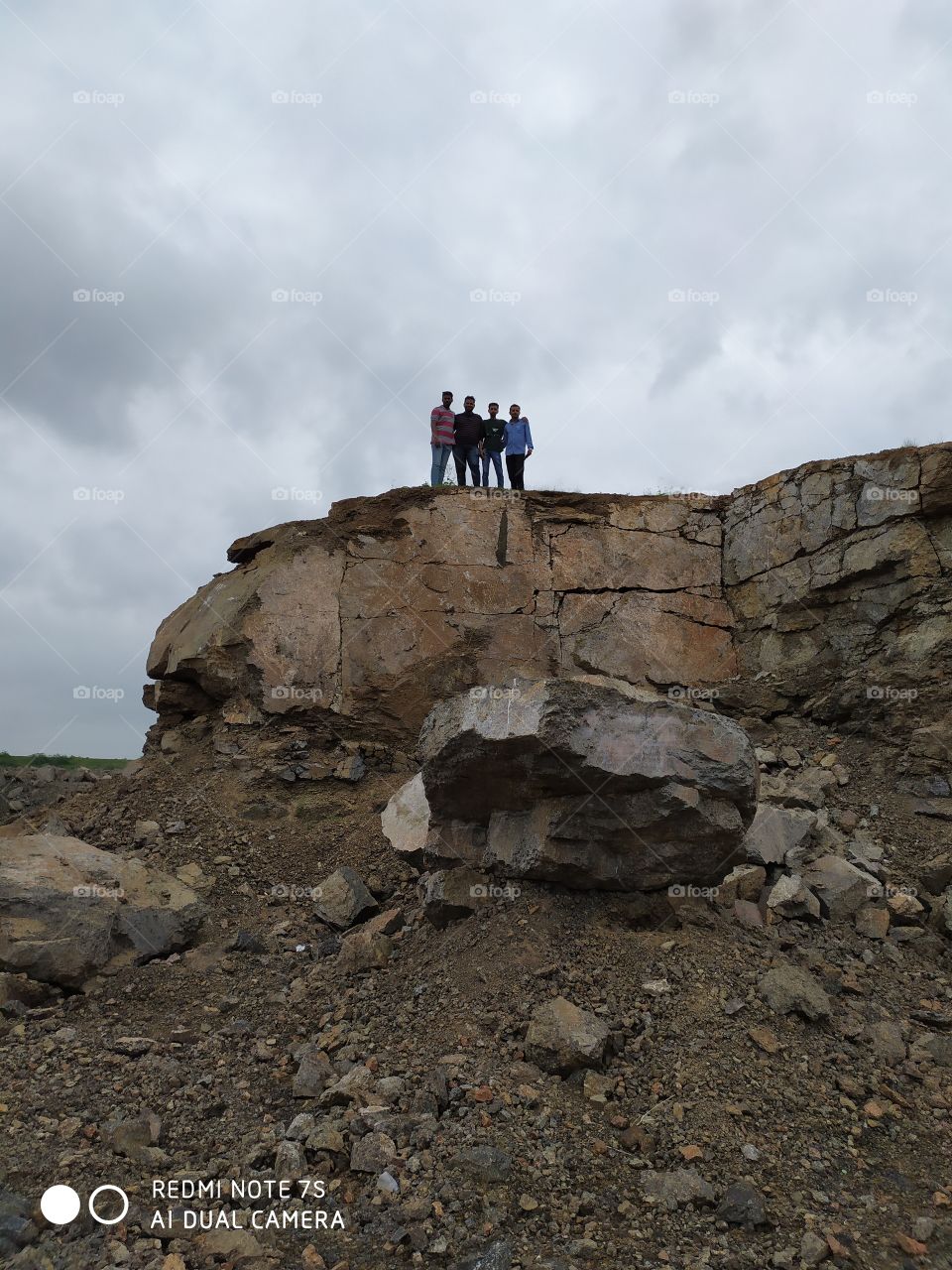 4 friends on mountains top under the cloudy sky