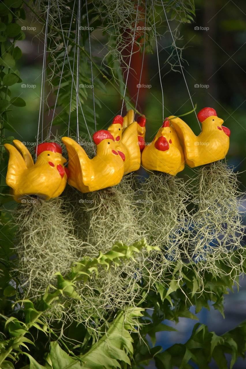 yellow hen hanging mobile in the garden.