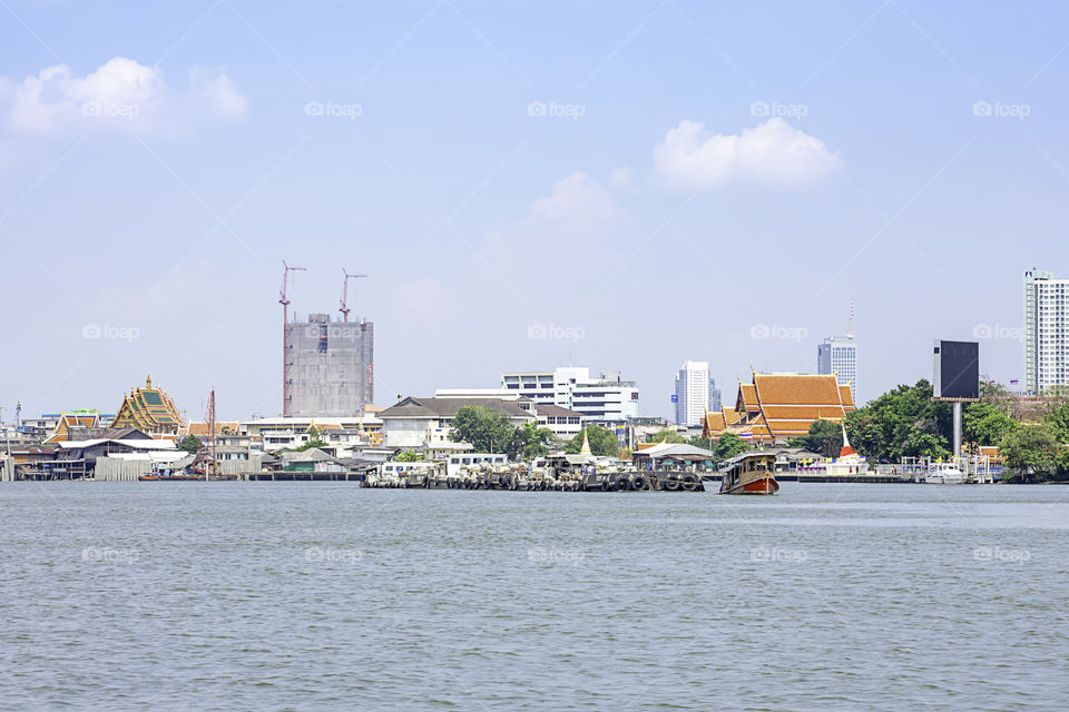 A boat load of sand in Chao Phraya River Background cityscape and sky at Pak kret in Nonthaburi , Thailand. April 16, 2019