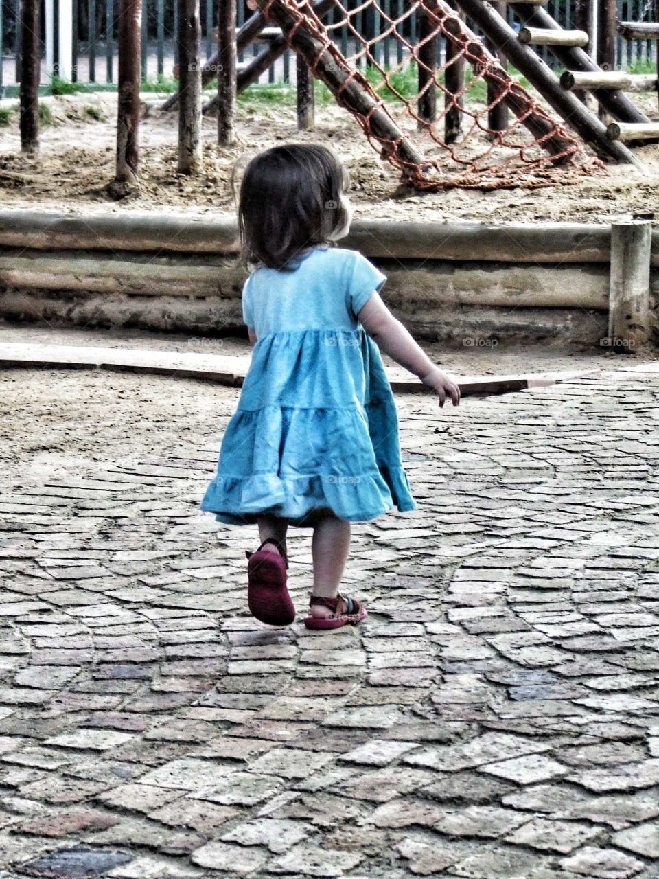 Little girl walking towards a play area