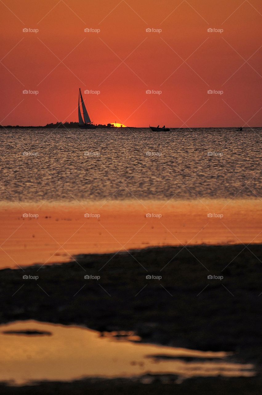 Silhouette of sailboat at sunset