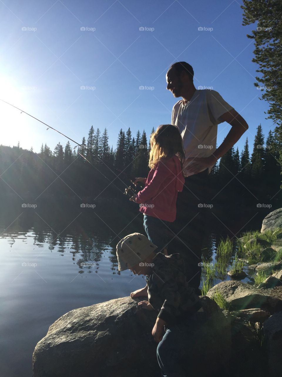 Father and daughter fishing at sunset
