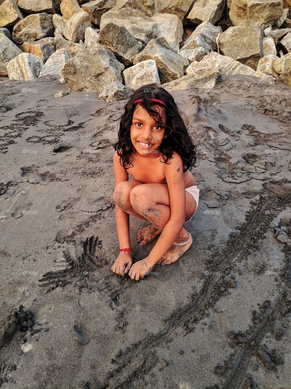 young girl busy in making sand castle..
