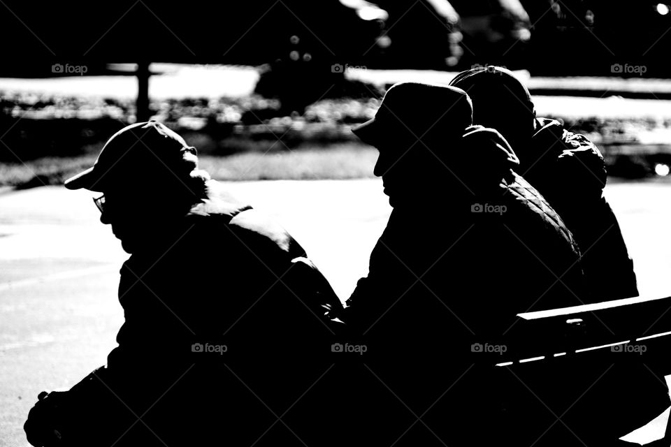 silhouette of elderly men sitting on a bench