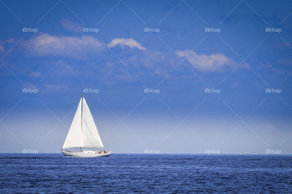 White sailboat with blue sky on Lake Michigan