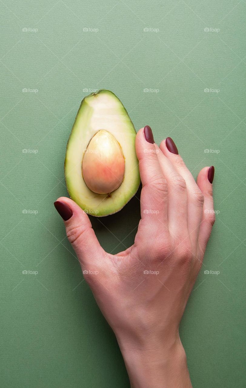 woman hand holding avocado