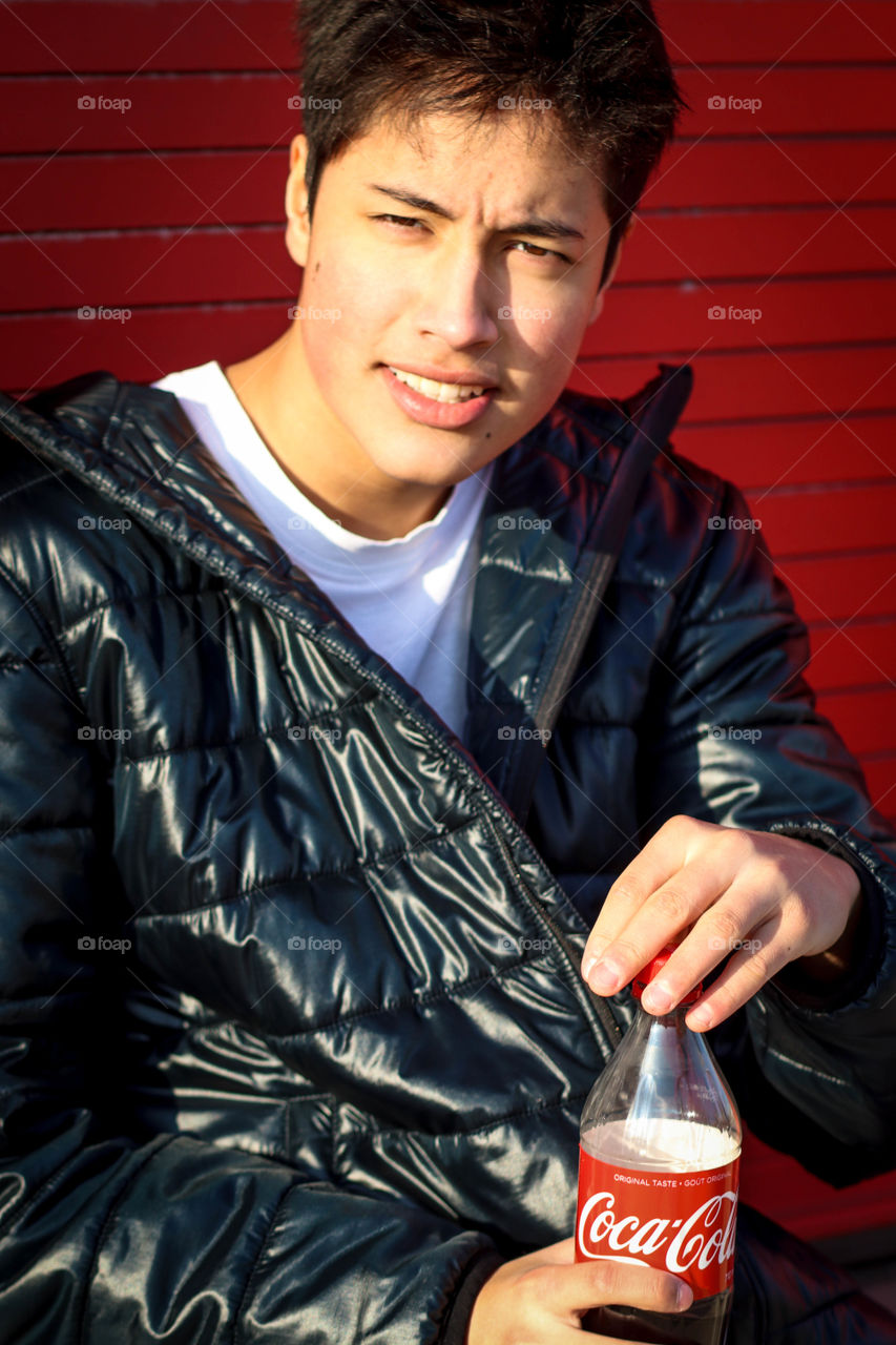 Young handsome man with a bottle of Coca-Cola