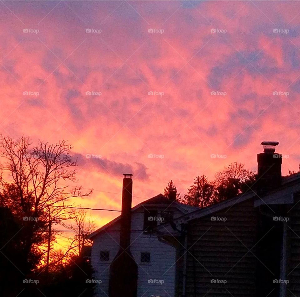 House silhouette in fiery sunrise.