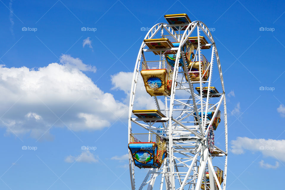 colorful carousel wheel against a blue sky in the traveling amusement park