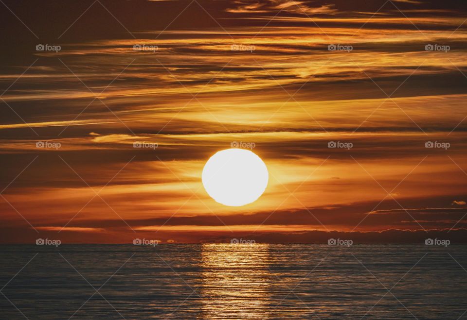 the most beautiful sunset in the baltic sea with a round sun