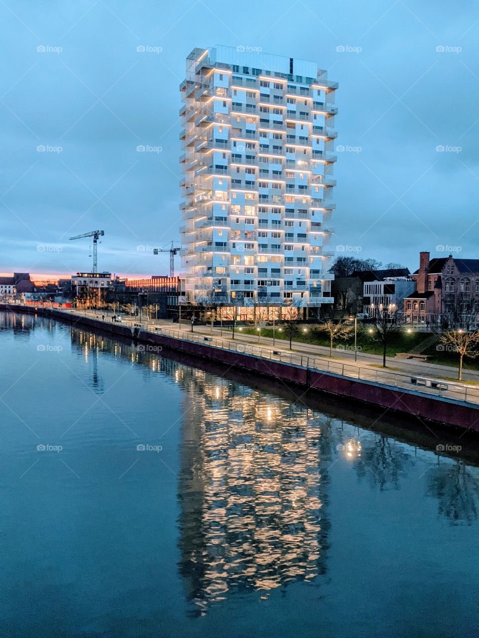 skyscraper mirrored in the river