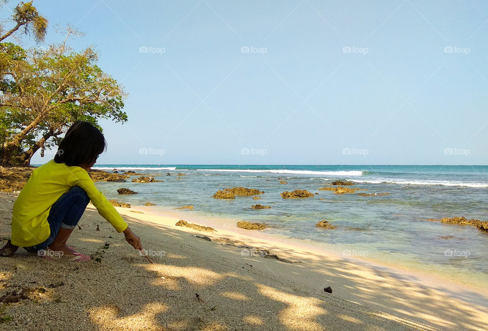a girl playing sand on the beach during the dry season
