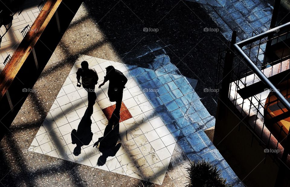 Two businessmen walking and talking in modern building