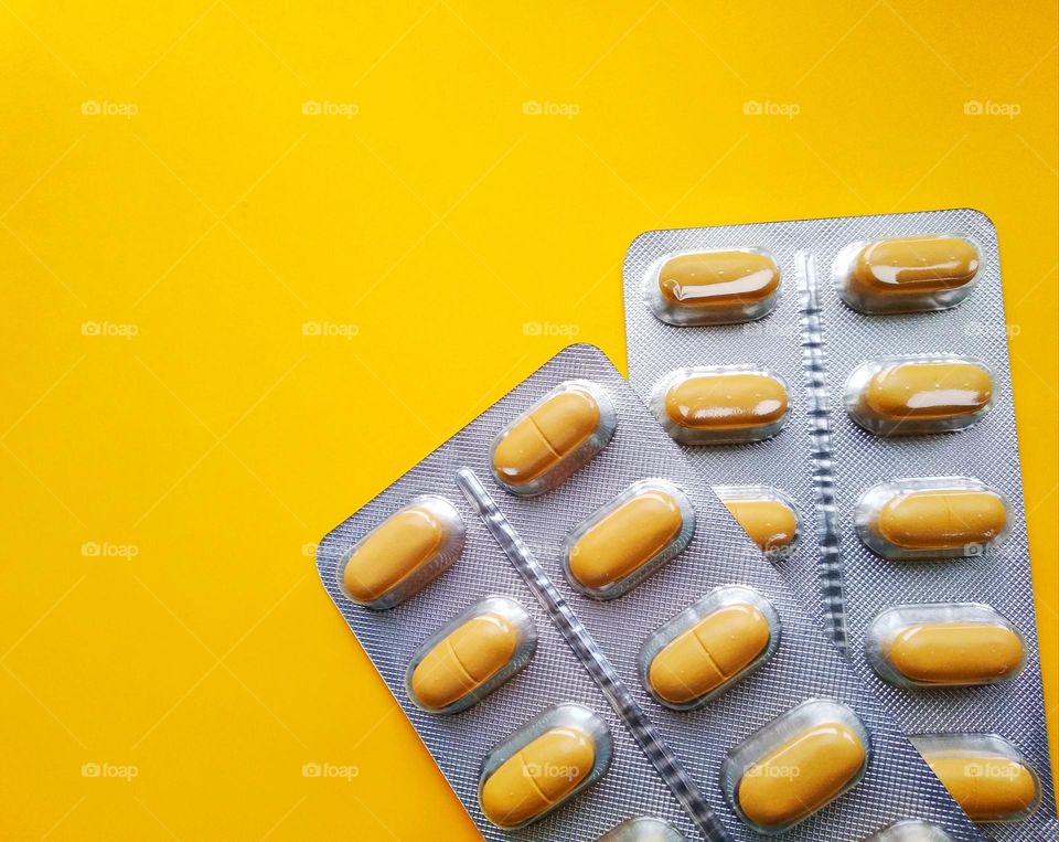 vitamins and minerals pills yellow background