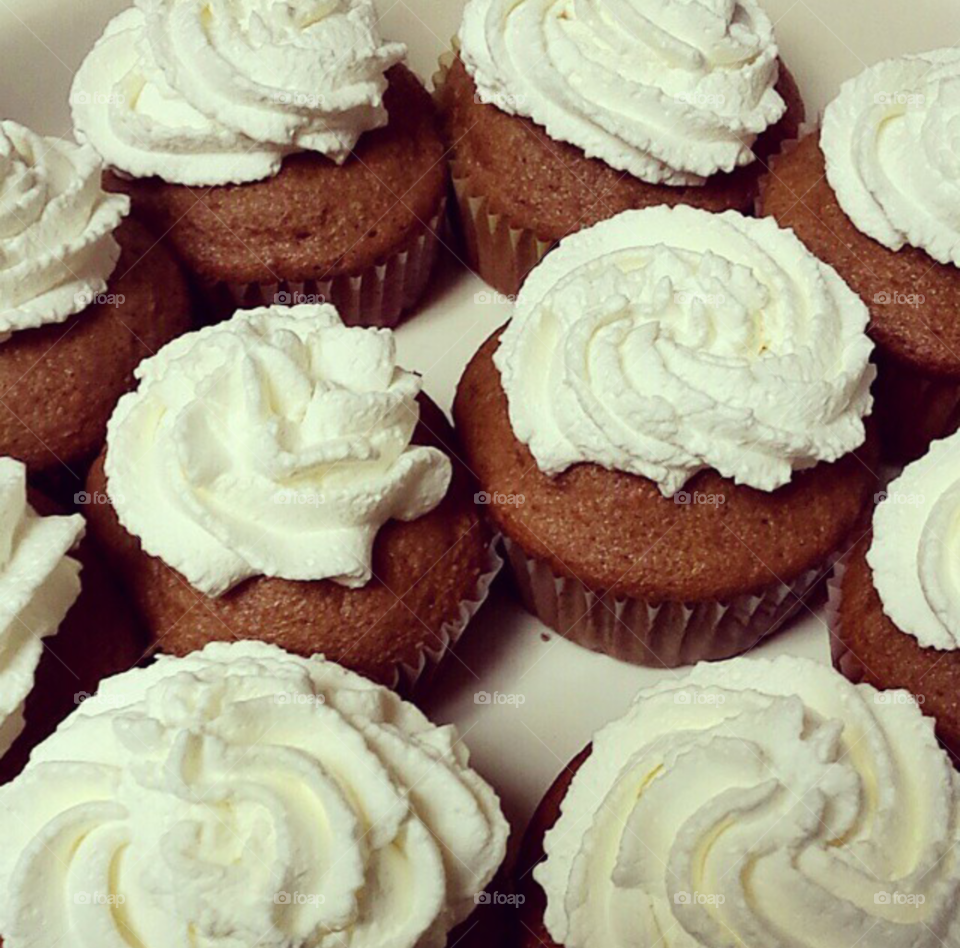 Homemade cupcakes topped with homemade whipped cream