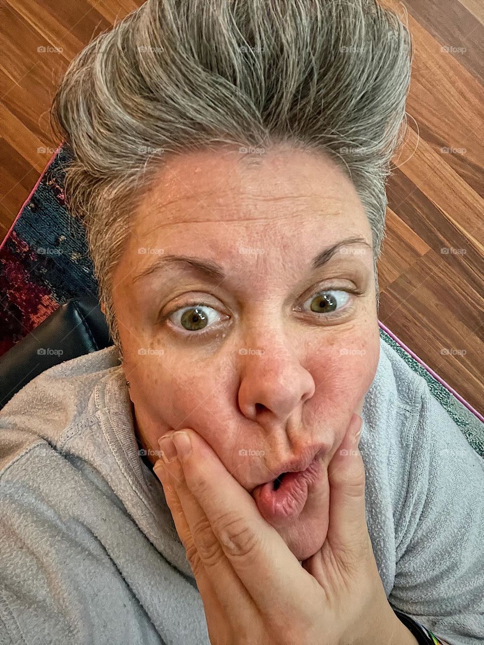 Woman squishes face for portrait, molding our faces, closeup of a woman’s face, skin care for your face, realistic portrait of a woman, natural light, woman’s face with funny expression