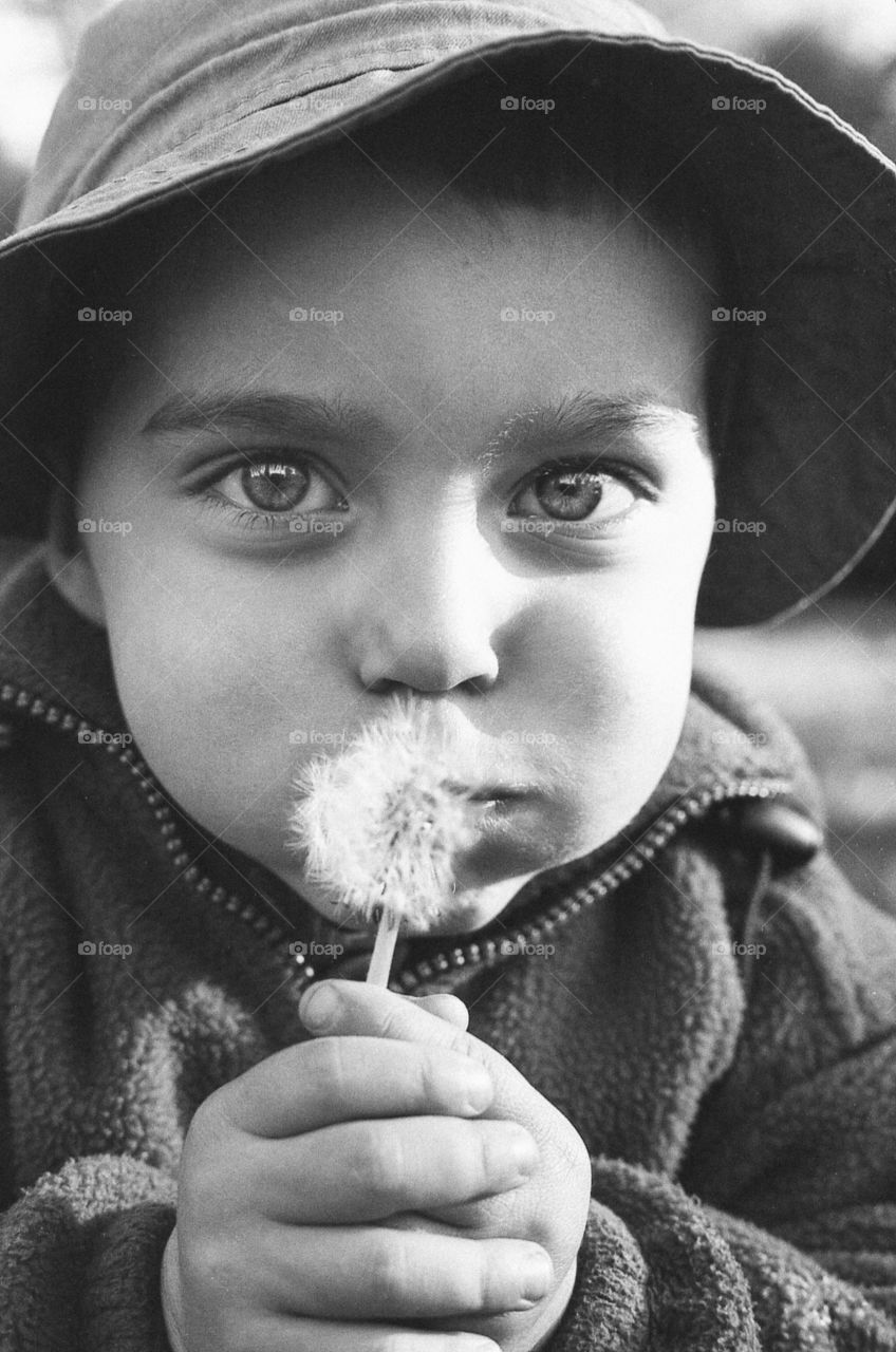 Boy blowing the dandelion