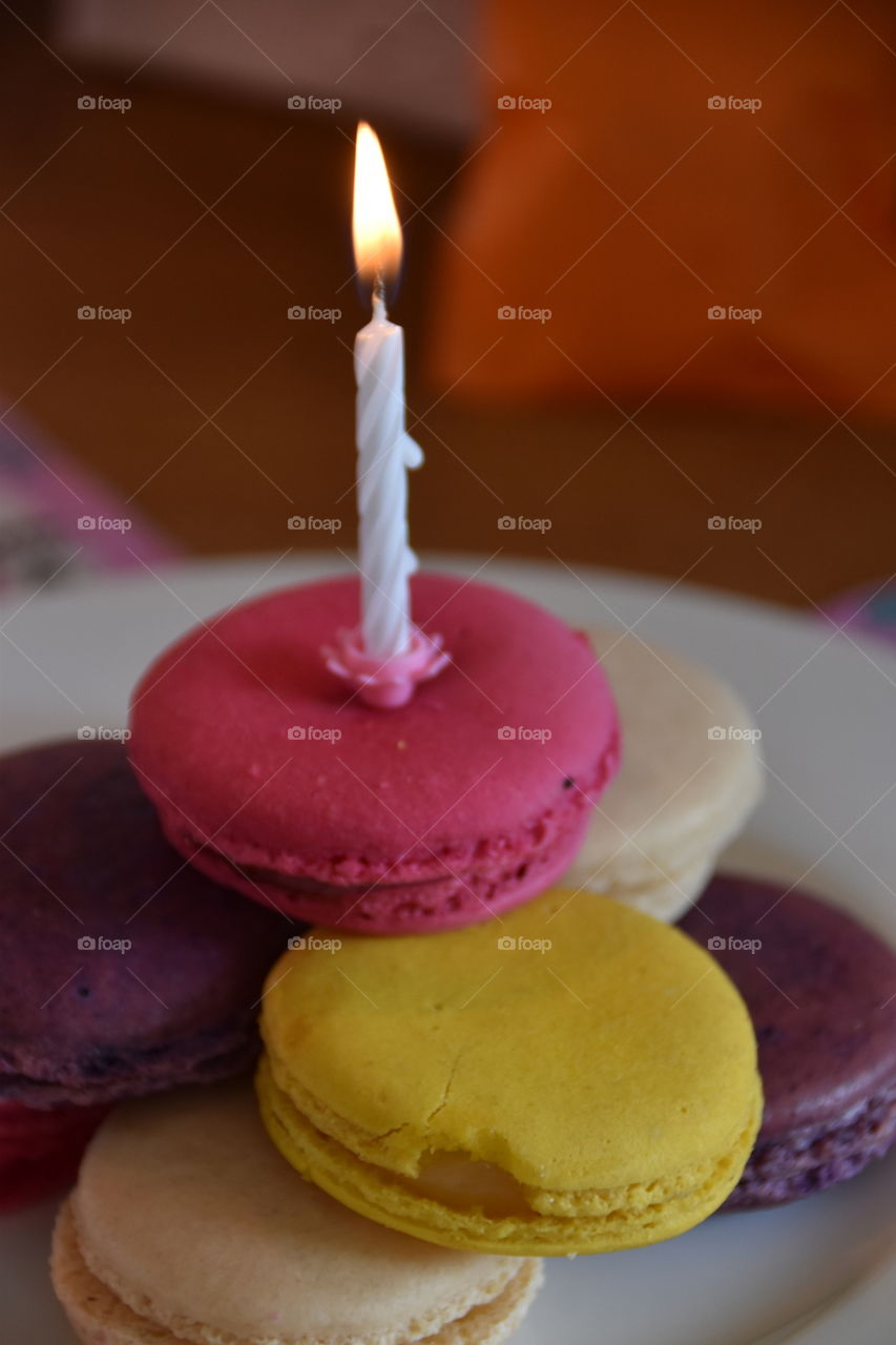 A burning candle on some macaroons 