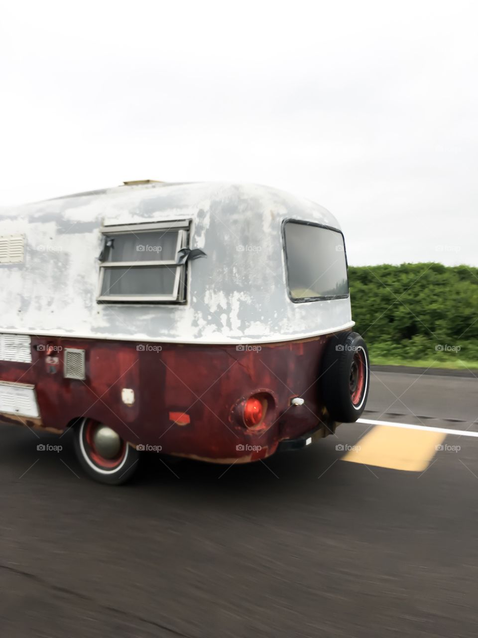 Vintage Red and white trailer camper conceptual fun travel road trip photography driving on highway 