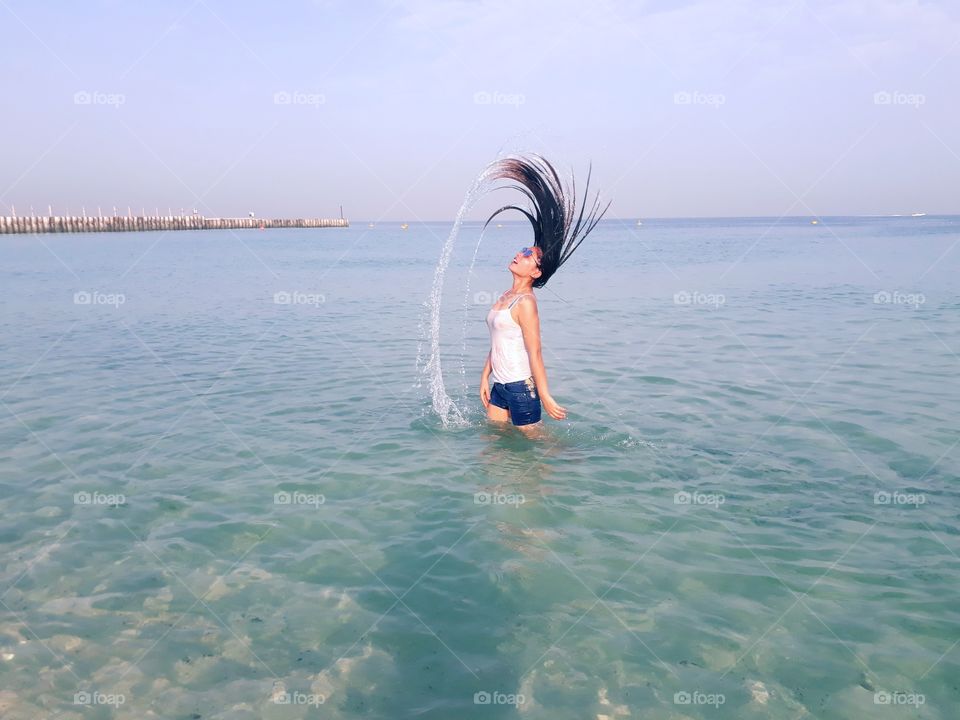 Beautiful lady on beach water splash