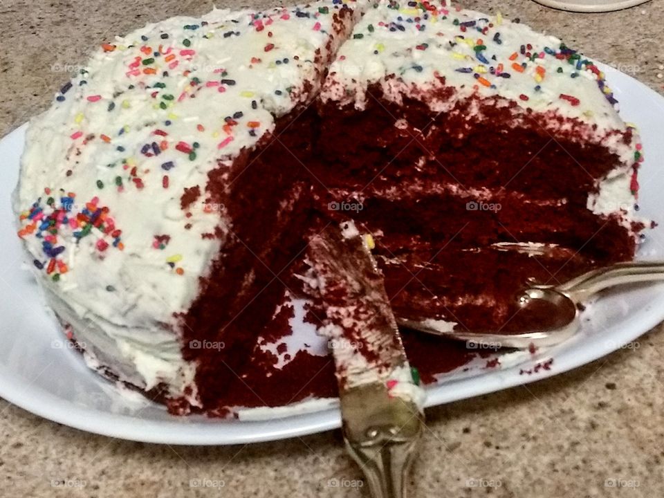 sliced homemade red velvet  cake with rainbow sprinkles