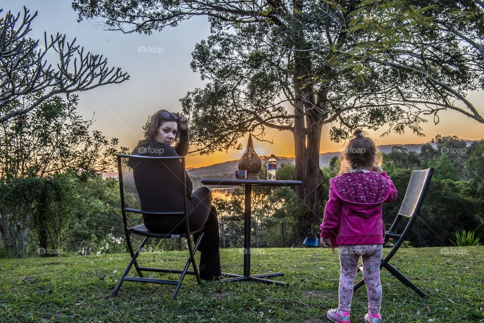 Mother and daughter enjoying sunset at park