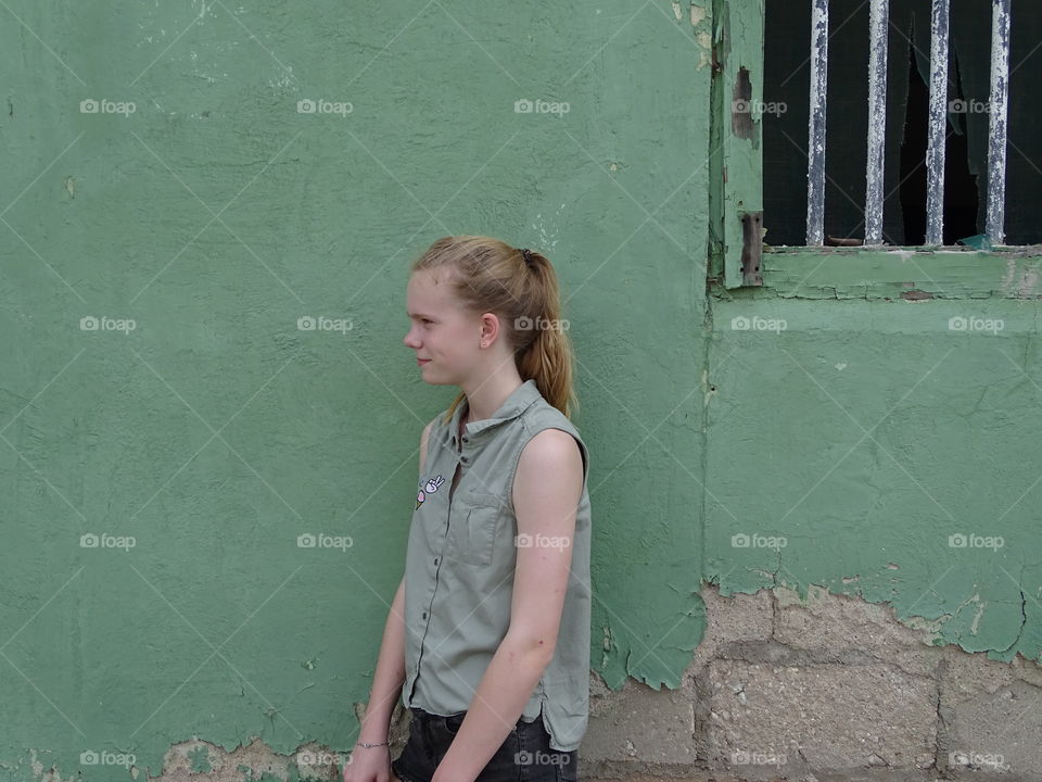 Girl in front of green wall