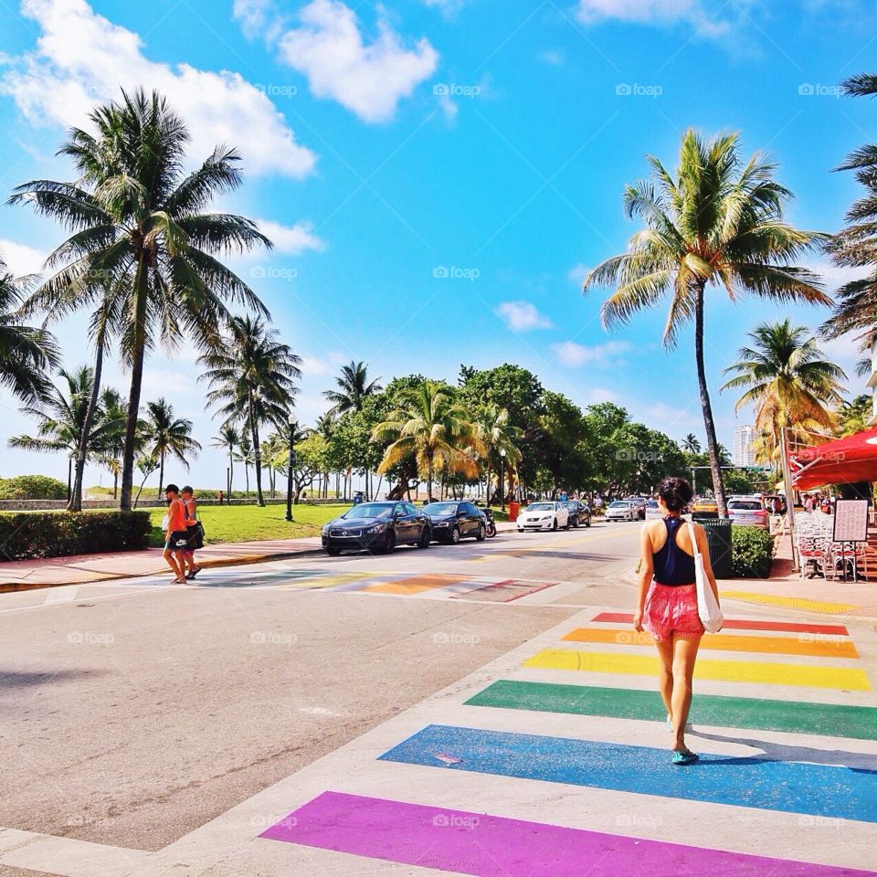 It's more fun in the sun . Girl walking down rainbow Boardwalk