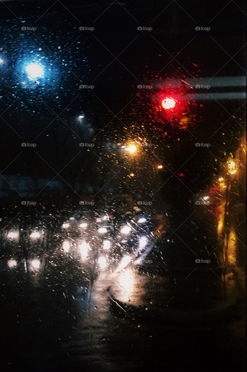 Rainy City lights through wet bus window. Lo-fi moody vibe and aesthetic. Cold City night.