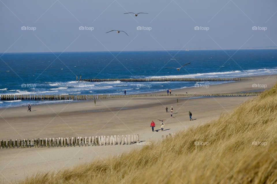 High angle view of sand beach by sea and sky.