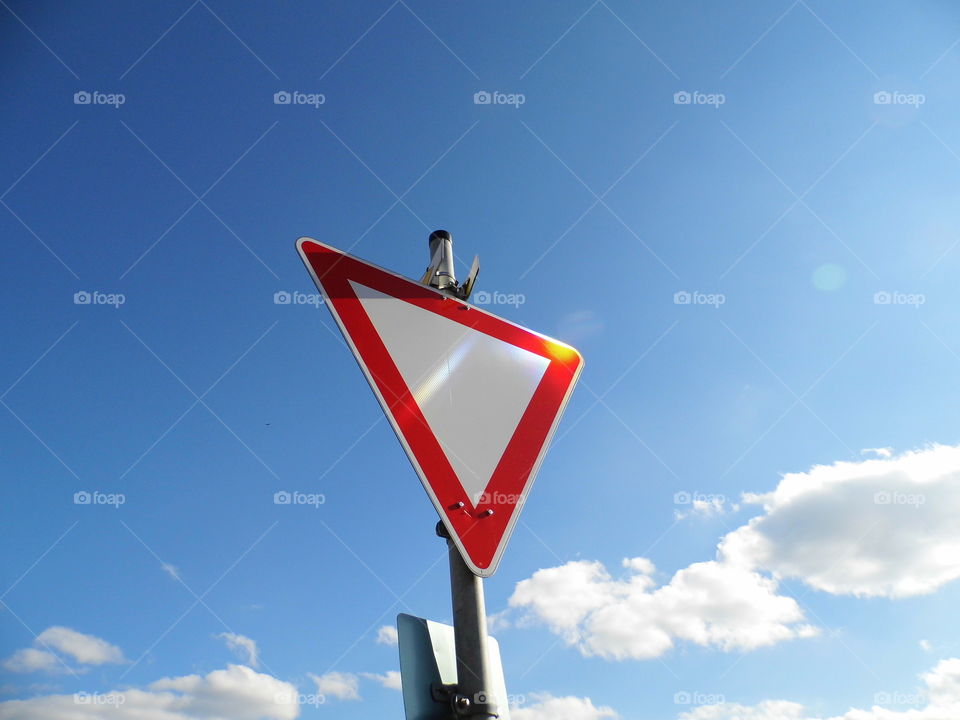 traffic signs give way and beautiful blue sky background and sunlight
