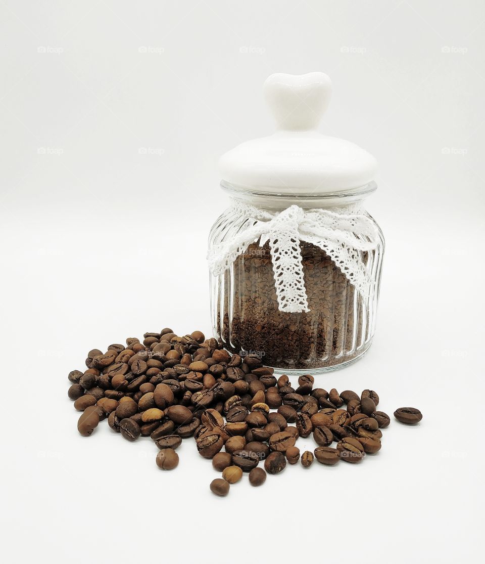 jar filled with coffee and roasted coffee beans on white background