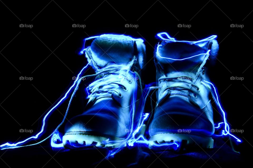 Work boots outlines with a blue light taken in complete darkness