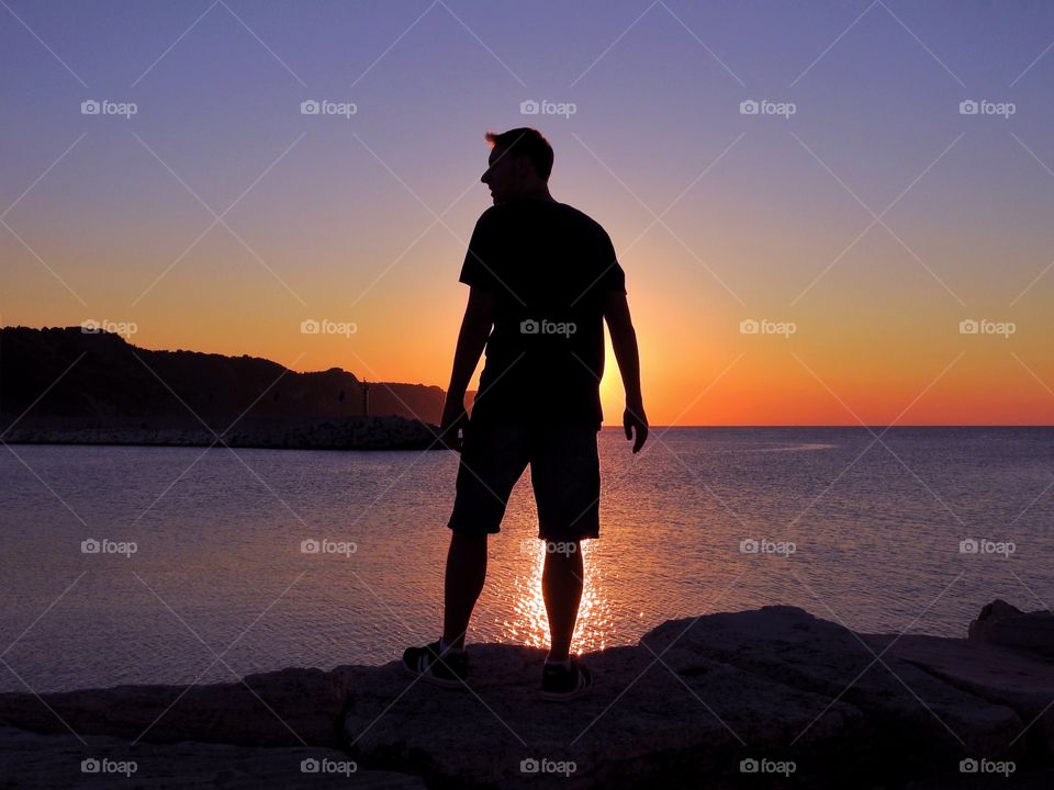 Silhouette of a man at sea sunset