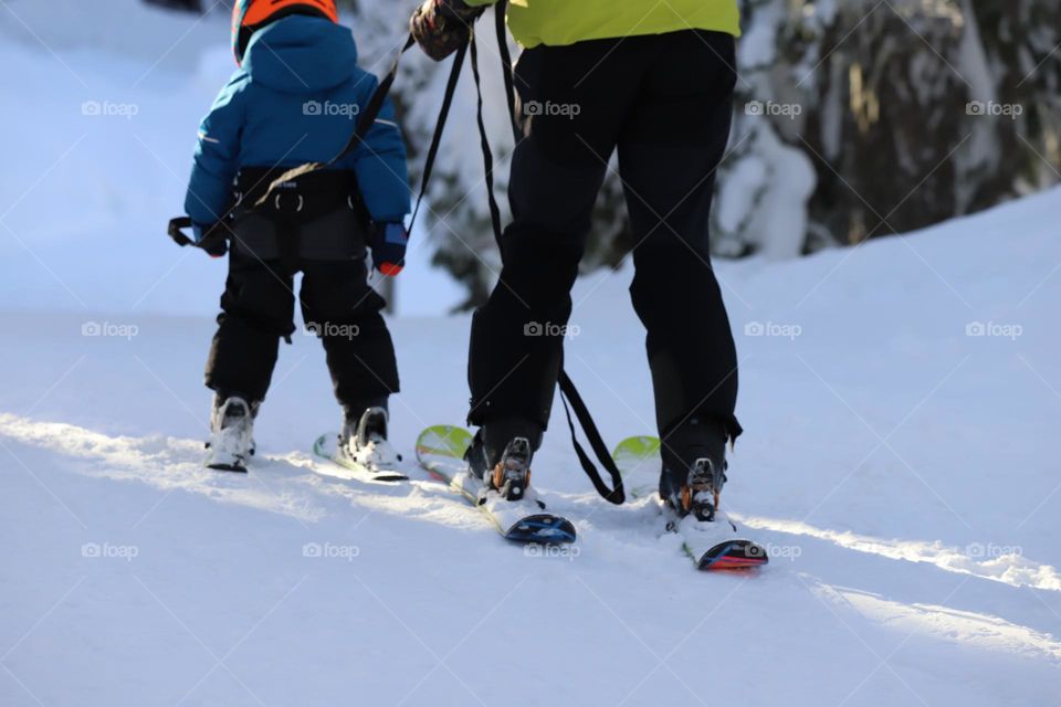 Skier teaching a kid to ski 