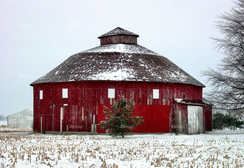 Red round barn in the snow. 