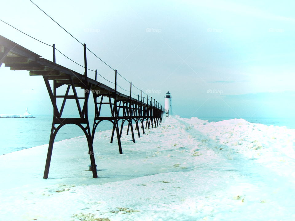 Snow covered cart walk and lighthouse